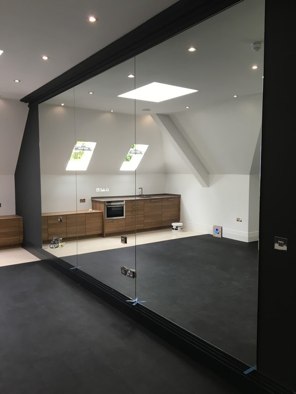 Frameless glass partition in loft conversion by Bermondsey glaziers